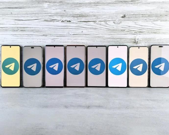 Reihe von Smartphones mit dem Telegram-Logo auf dem Bildschirm in verschiedenen Farben.
