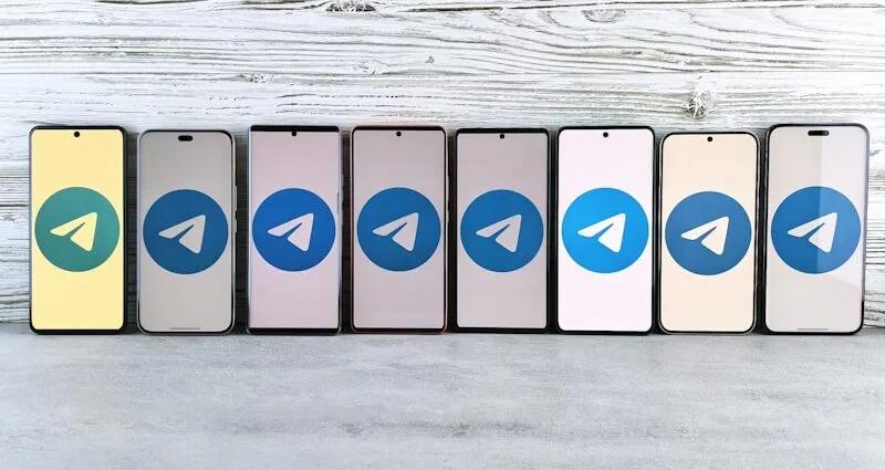 Reihe von Smartphones mit dem Telegram-Logo auf dem Bildschirm in verschiedenen Farben.